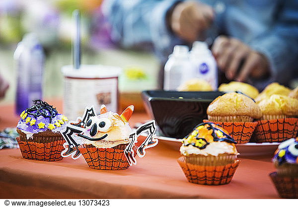Various decorated muffins at table during Halloween party