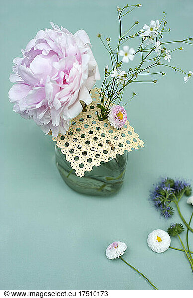 Various flowers in handmade jar with Viennese braid