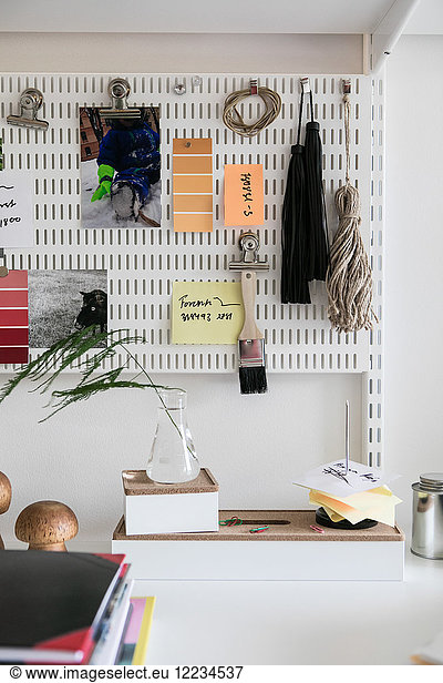 Various objects hanging on pegboard at home office