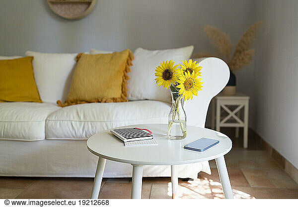 Vase with sunflowers  mobile phone and diary on table in living room at home