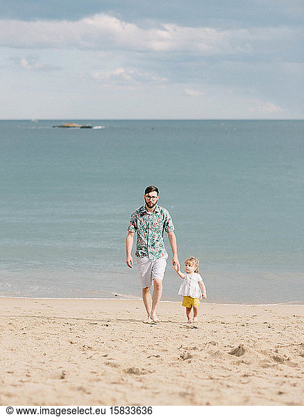 Vater-Tochter-Duo im Urlaub am Strand.