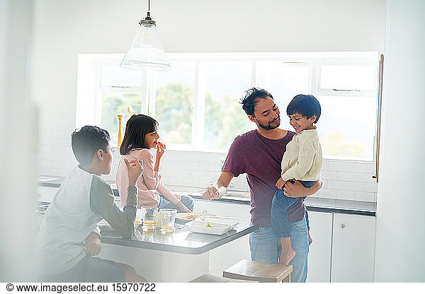Vater und Kinder essen in der Küche