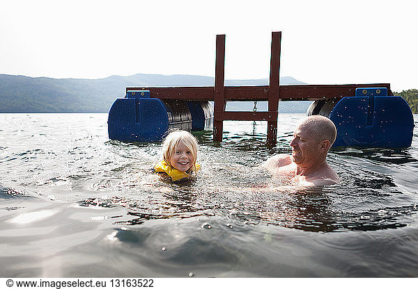 Vater und Kleinkind schwimmen im See  Silver Bay  New York  USA