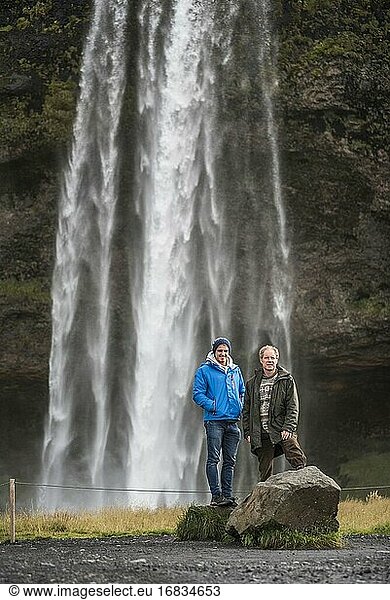 Vater und Sohn am Seljalandsfoss  einem berühmten Wasserfall direkt an der Route 1 in Südisland (Sudurland)