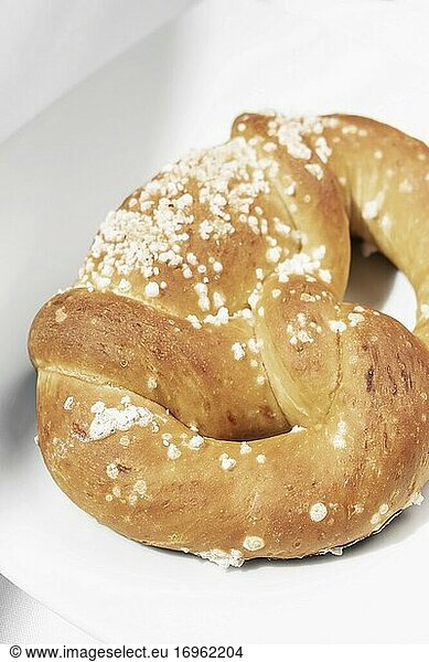 Vegan dairy-free organic german traditional pretzel bread on white table.