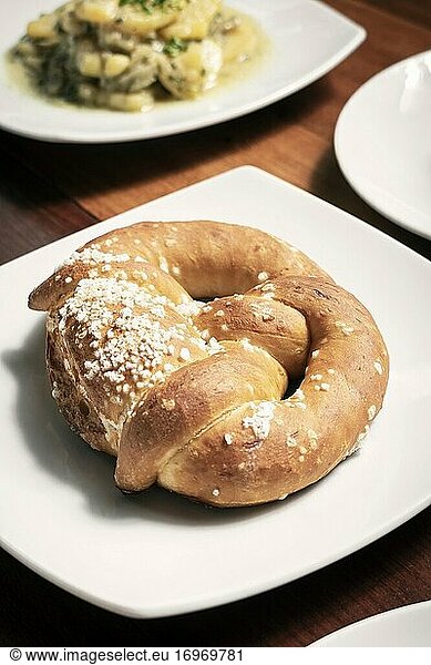 Vegan dairy-free organic german traditional pretzel bread on wood table.