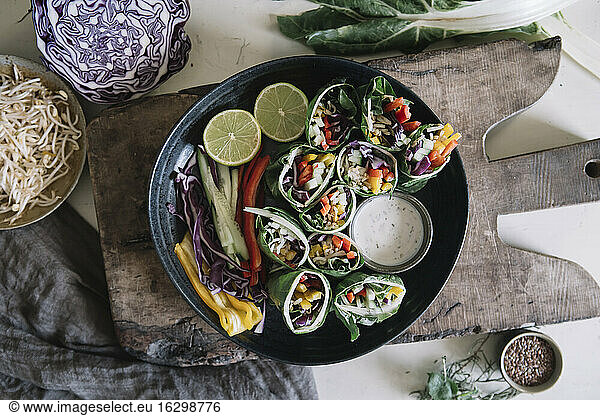 Vegan rolls with vegetables and yoghurt sauce in bowl