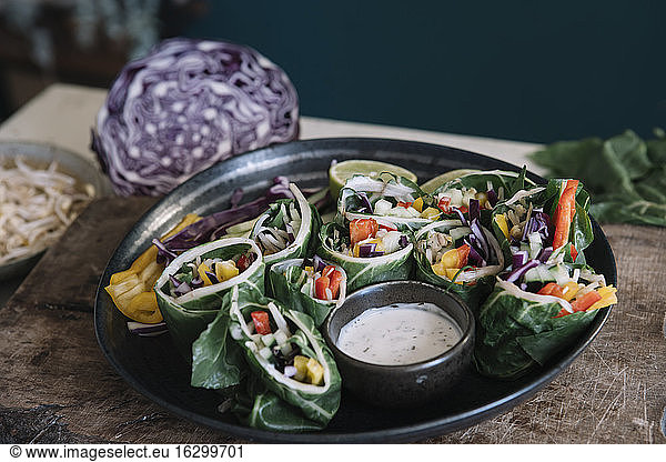 Vegan rolls with vegetables and yoghurt sauce in bowl