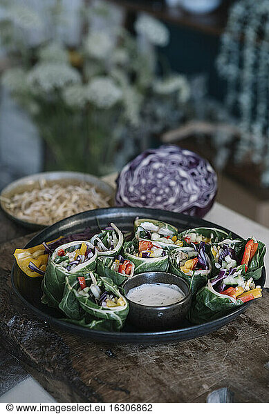 Vegan rolls with vegetables and yoghurt sauce in bowl