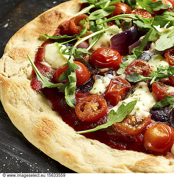 Vegetarian pizza with cherry tomatoes  arugula  MozzarellaÂ and onions