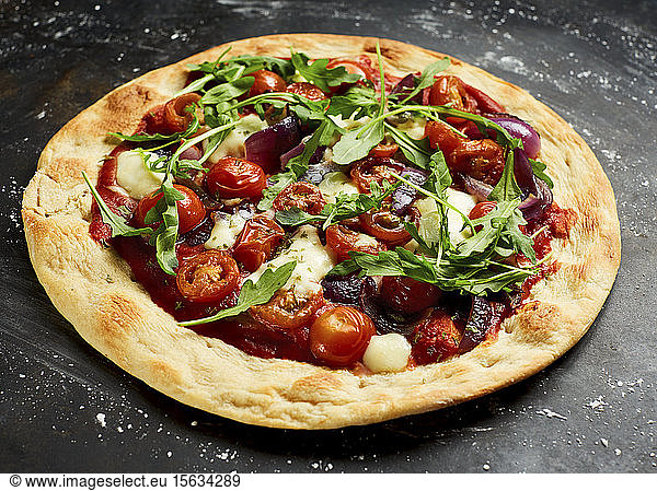 Vegetarian pizza with cherry tomatoes  arugula  Mozzarella and onions