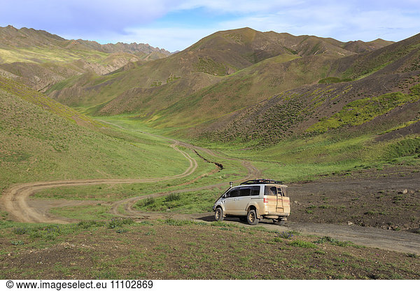 Vehicle travels off road through lush mountains  Gurvan Saikhan National Park  near Yolyn Am (Yol Valley)  Gobi Desert  Mongolia  Central Asia  Asia