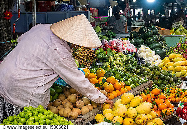 Vendor at his fruit and vegetable stall at a market in Hoi An  Vietnam.