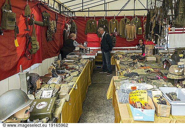 Vendor in WWII stand selling military artifacts to World War Two collector at WW2 militaria fair