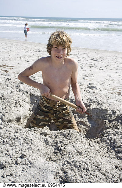 Vereinigte Staaten von Amerika USA Strand Junge - Person Sand graben gräbt grabend