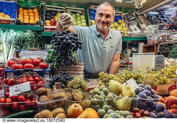 Verkäuferin auf einem Lebensmittelmarkt des Mercato Delle Erbe in Bologna  der Hauptstadt und größten Stadt der Region Emilia Romagna in Norditalien.