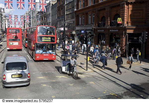 Verkehr auf der Oxford Street  Doppeldeckerbusse  Fahrradtaxi  Union Jack  Nationalflagge  London  England  Gro_britannien  Europa