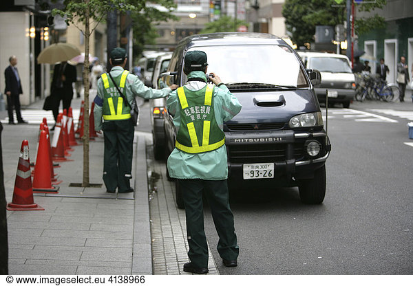 Verkehrspolizei Politessen im Stadtteil Ginza dokumentieren aufwändig einen Falschparker Tokio Japan