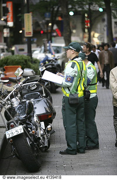 Verkehrspolizei Politessen im Stadtteil Ginza dokumentieren aufwendig einen Falschparker  Motorrad auf dem Gehweg  Tokio  Japan  Asien