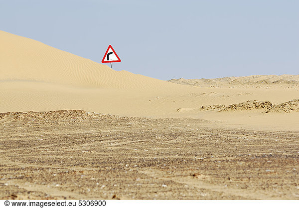 Verkehrsschild hinter Sanddüne zwischen Oase Farafra und Oase Dakhla  Libysche Wüste  Ägypten  Afrika