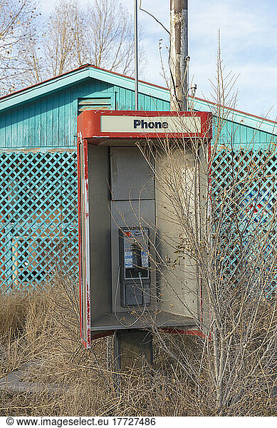 Verlassene alte Telefonzelle und verlassener Laden am Straßenrand.