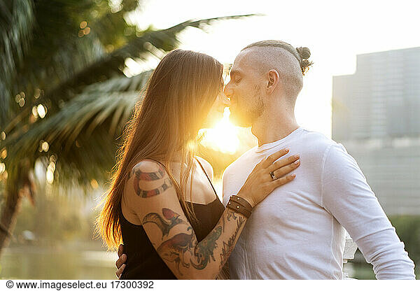 Verliebtes Paar bei Sonnenuntergang im Sonnenschein in tropischer Metropole