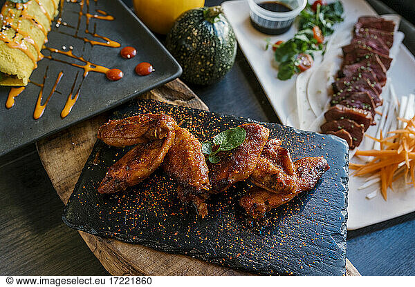 Verlockende Hähnchenflügel und Fleisch im Restaurant serviert