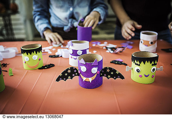 Verschiedene Halloween-Dekoration bei Tisch mit Menschen im Hintergrund