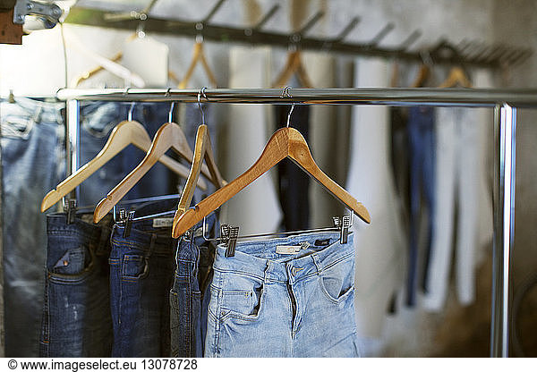 Verschiedene Jeans  die auf Kleiderbügeln hängen