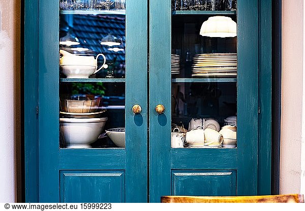Verschiedene weiße Gerichte in Schrank in der Küche Vintage-Design mit blauen Farben Retro.