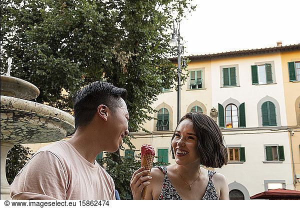 Verschiedenes lachendes Paar mit Gelato auf der italienischen Piazza