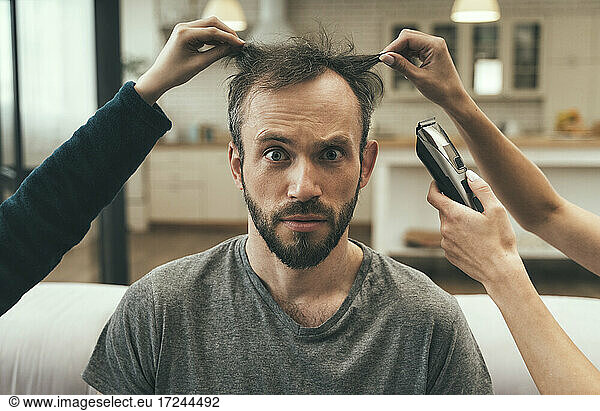 Verwirrter Mann beim Haarschnitt zu Hause