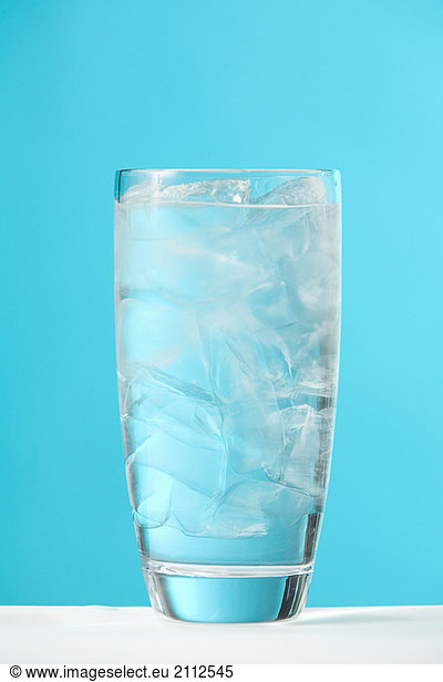 Very full glass of water with ice
