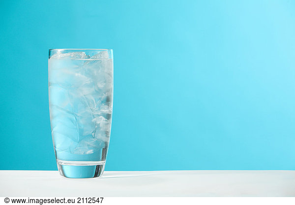 Very full glass of water with ice