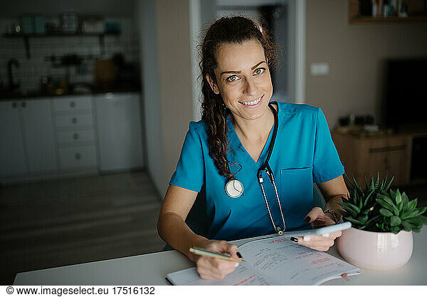 Veterinarian holding a pen and a phone in her office.