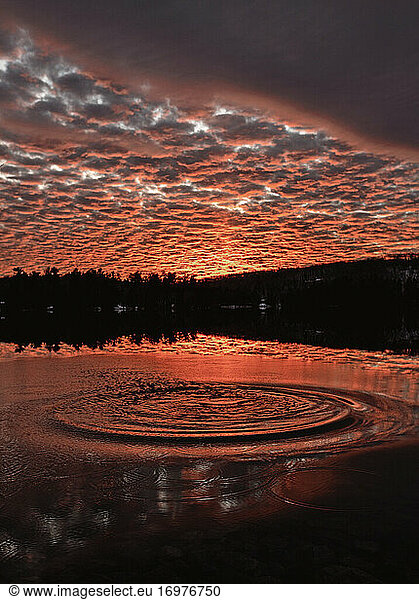 vibrant red sunset over Round Pond  Maine with ripple on water