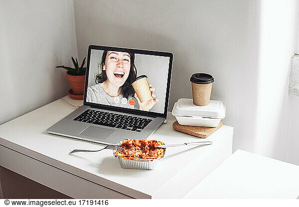 Video call with woman with a take away cup  aluminium box with food