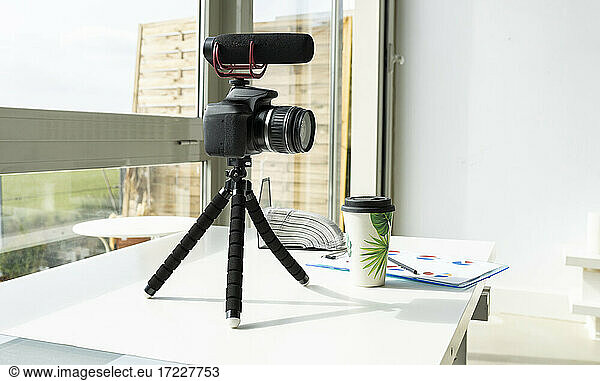 Video camera with reusable cup on table at home