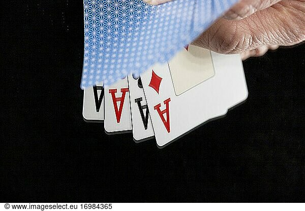 Vier Asse aus einem Kartenspiel in einer Hand.