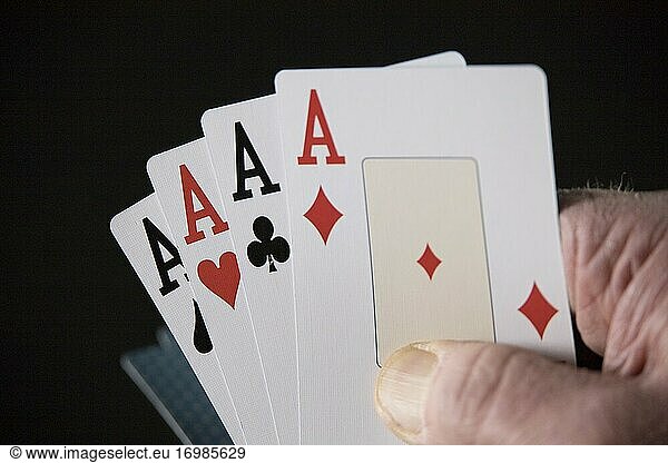 Vier Asse aus einem Kartenspiel in einer Hand.