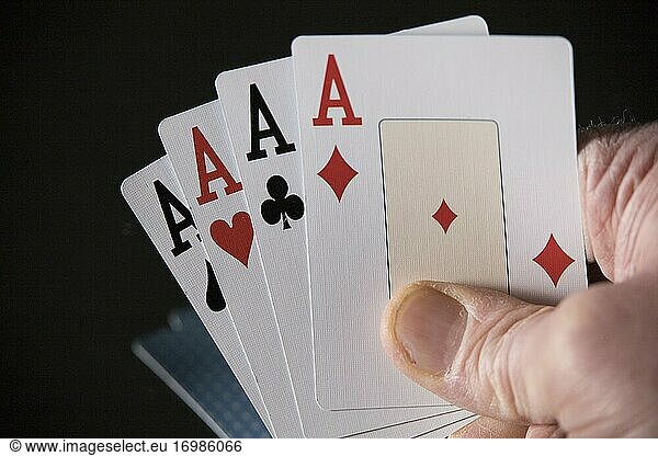 Vier Asse aus einem Kartenspiel in einer Hand.