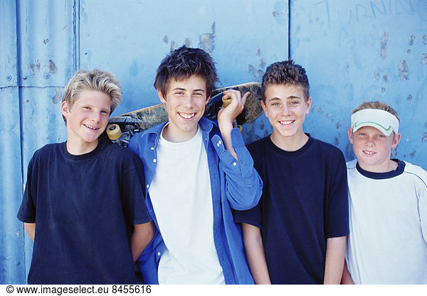 Vier kleine Jungen in einer Reihe  Freunde skateboarden.