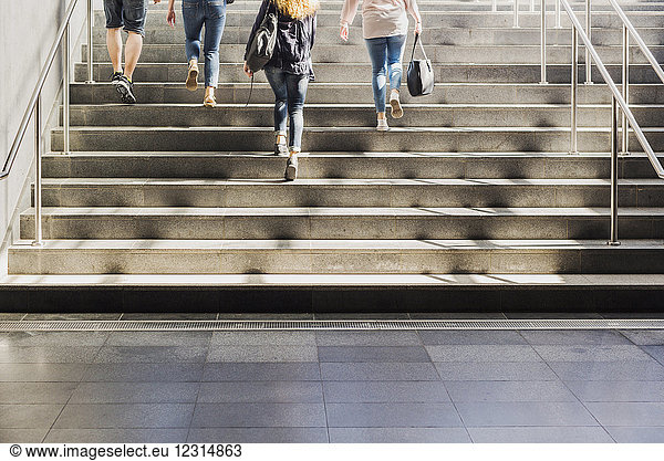 Vier Personen gehen eine Treppe hinauf