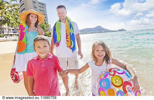Vierköpfige Familie im Sommerurlaub in Waikiki Beach; Waikiki  Oahu  Hawaii  Vereinigte Staaten von Amerika'.