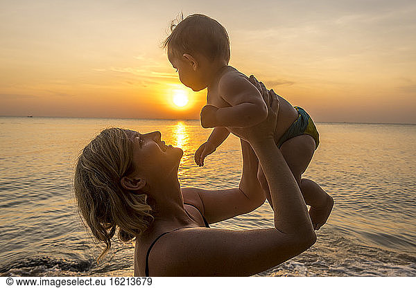 Vietnam  Phu Quoc island  Ong Lang beach  Mother holding baby in beach at sunset