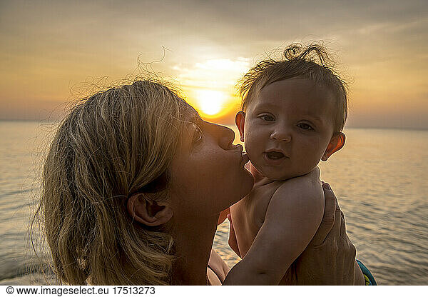Vietnam  Phu Quoc island  Ong Lang beach  Mother kissing baby in beach at sunset