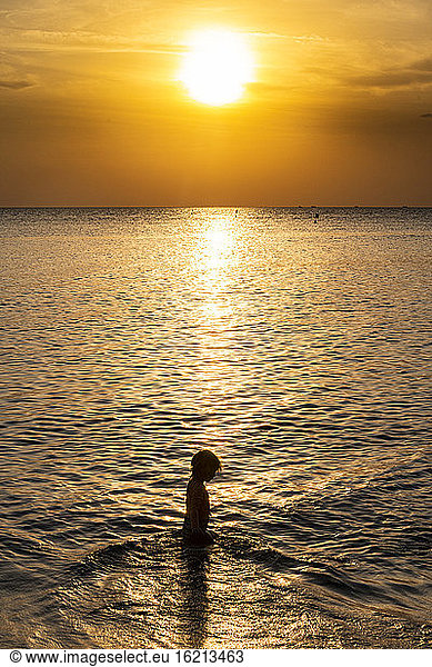 Vietnam  Phu Quoc island  Ong Lang beach  Silhouette of girl in sea at sunset