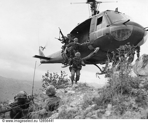 VIETNAM WAR: HELICOPTER. Members of a U.S. reconnaissance platoon of the 1st Cavalry Division jumping from a UH-1D helicopter onto a ridge near Duc Pho  in Quang Ngai province  South Vietnam  during the Operation Oregon search and destroy mission  24 April 1967. Photographed by Sgt. Howard C. Breedlove.