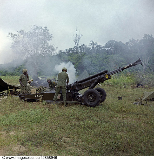 VIETNAM WAR  1966. US Army soldiers firing an M102 howitzer in the direction of Viet Cong. Photograph 6 July  1966.