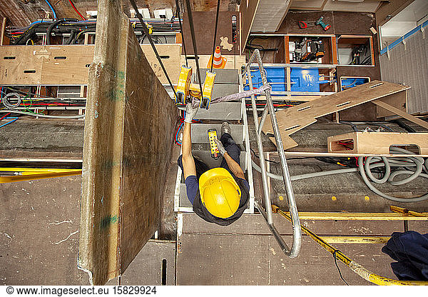 View from above of a man using a wireless remote control for a crane